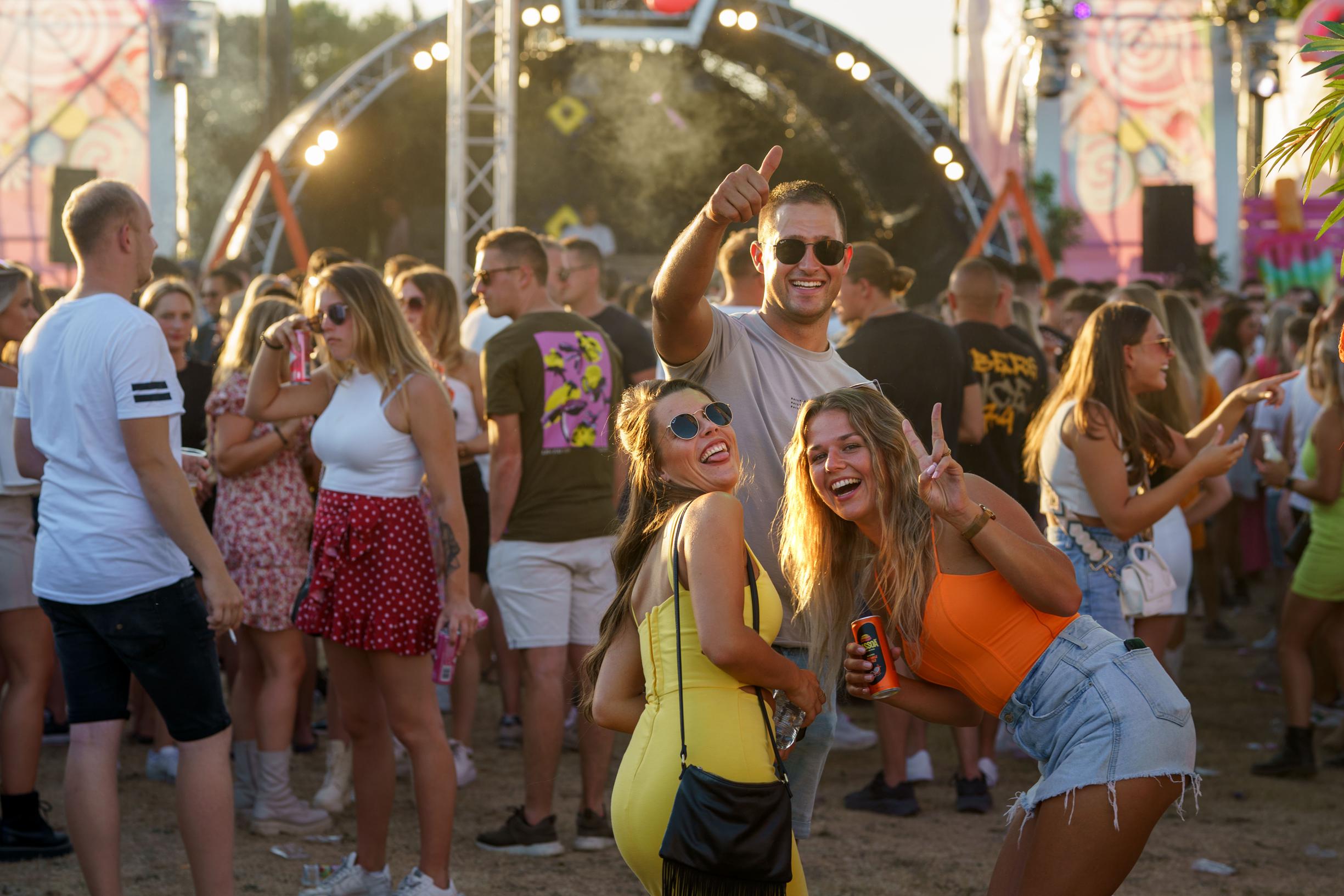 Bezoekers van loeihete editie Alfa Open Air zoeken op festivalwei verkoeling onder legernetten