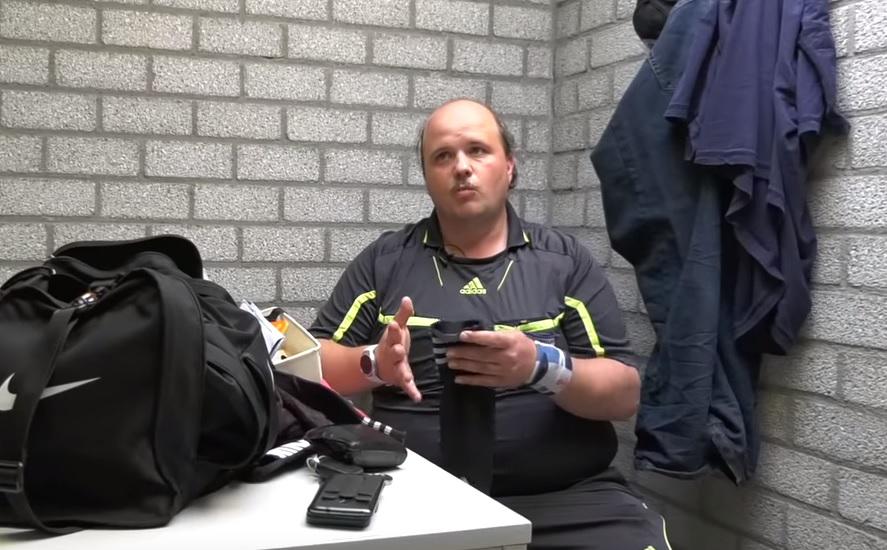 Parkeerwachter op voetbalveld bedreven in uitdelen prenten