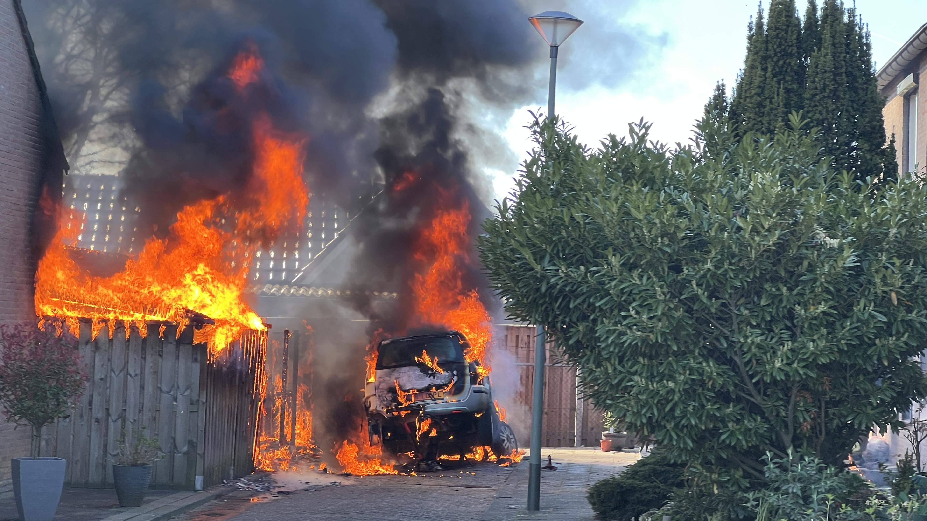 Persoon loopt brandwonden op bij overslaande autobrand in Swalmen, woningen en schutting lopen schad