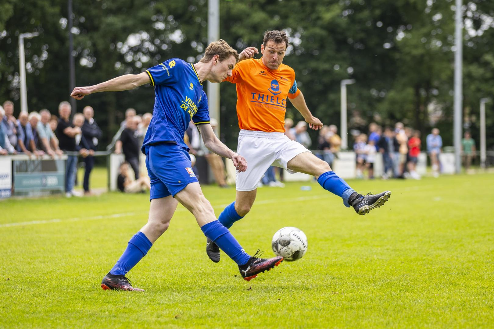Reuver-aanvoerder Ruud Zegers in duel met een speler van DVG.