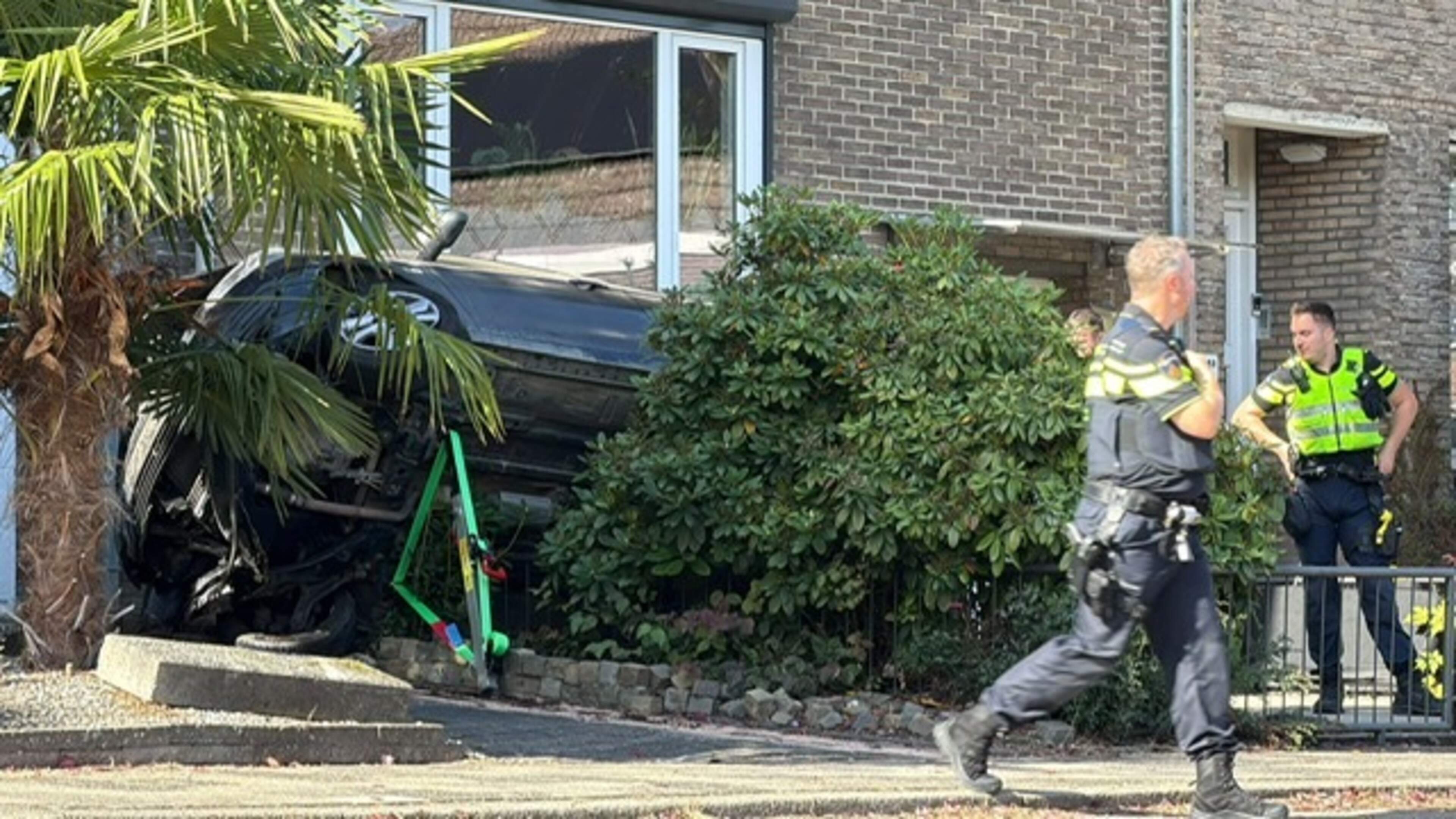 Auto belandt op zijkant in voortuin na botsing tegen woning in Heerlen